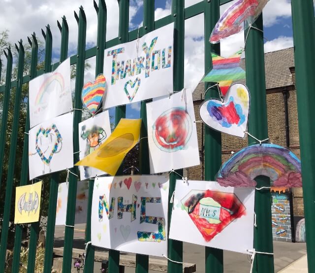 Fence with children's drawings supporting the NHS